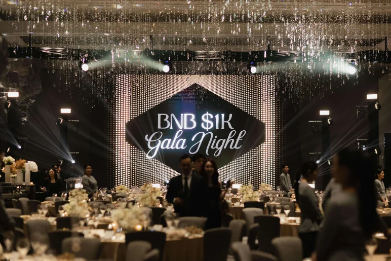 The BNB $1K Gala Night stage in a ballroom set with dinner tables